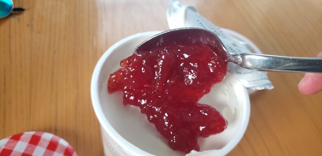 A heaping tablespoon of Bonne Maman strawberry preserves over an open tub of skyr.
