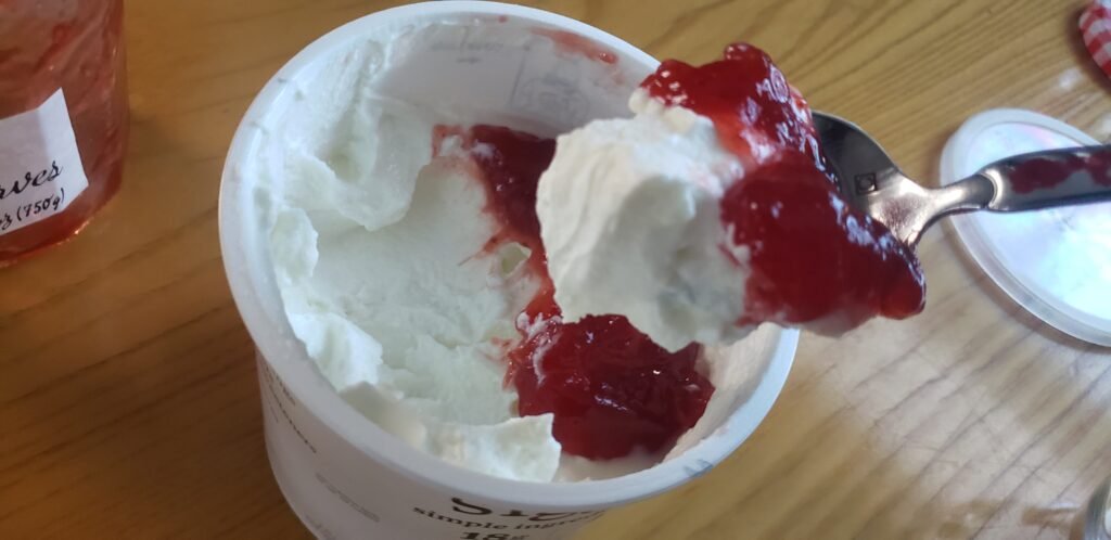 A heaping tablespoon of Bonne Maman strawberry preserves over an open tub of skyr.